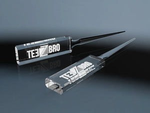 Two crystal glass letter openers with an engraved logo on a reflective surface