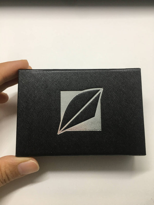 Schwarze Geschenkbox mit silbernem Blatt-Motiv auf weißem Hintergrund, Werbeartikel Verpackung