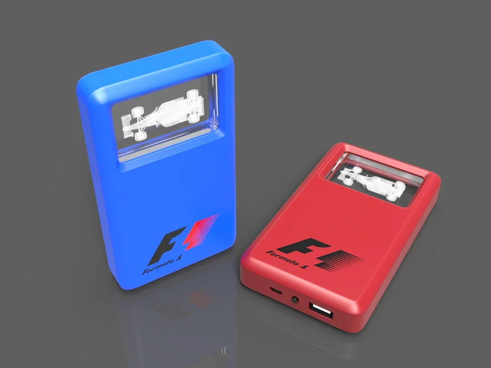 Zwei Powerbanks in Blau und Rot mit eingraviertem Formel-1-Auto aus Kristallglas.