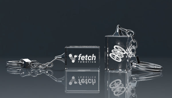 Engraved crystal glass keyring with a metal ring on a reflective surface