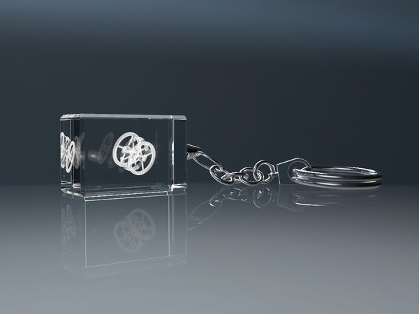 Engraved crystal glass keyring reflected on a glossy surface