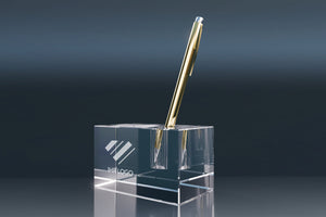 Crystal glass pen holder with an engraved logo and gold ballpoint pen