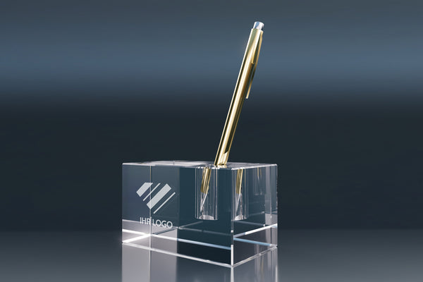 Crystal glass pen holder with an engraved logo and gold ballpoint pen