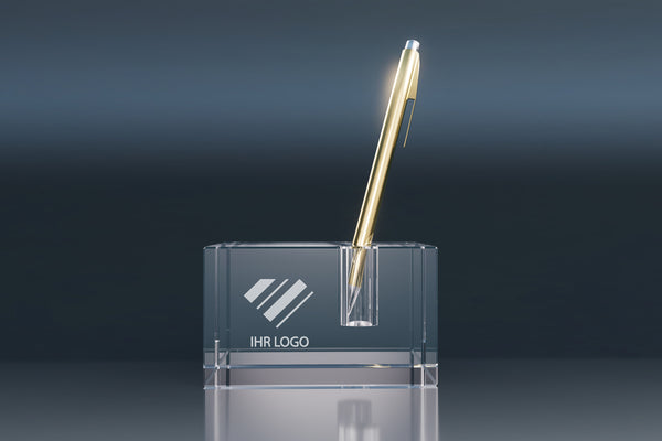 Transparent crystal glass pen holder with an engraved logo and gold ballpoint pen