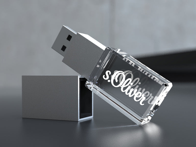 USB-Stick aus Kristallglas mit Gravur und silberner Kappe auf dunklem Hintergrund